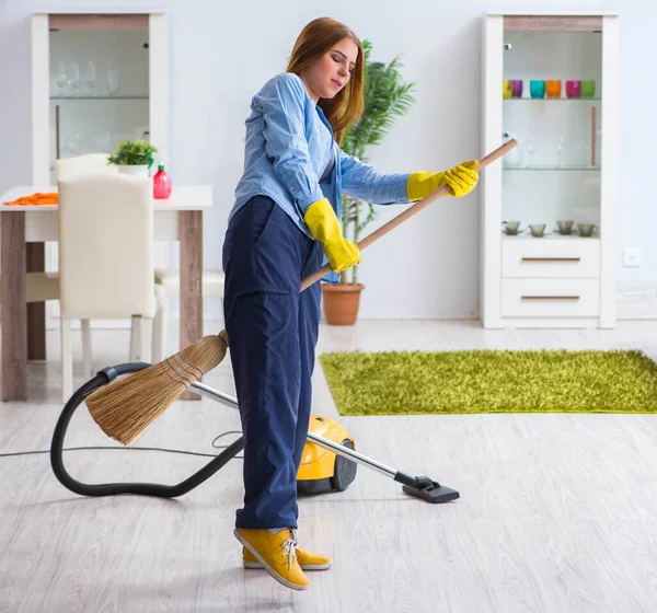 Evdeki yerleri temizleyen genç bir kadın.