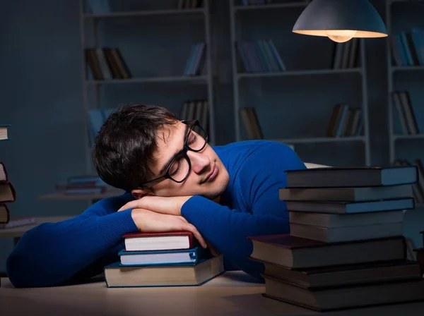 Estudiante preparándose para los exámenes tarde en la noche en la biblioteca — Foto de Stock