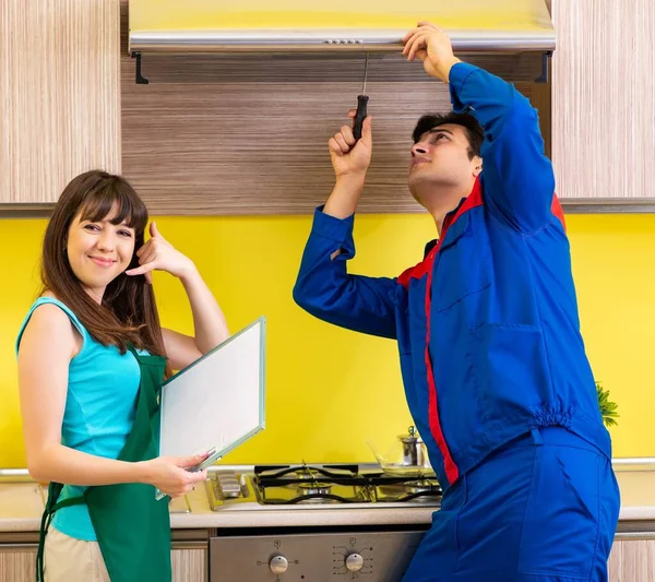 Mulher com empreiteiro na cozinha discutindo reparação — Fotografia de Stock