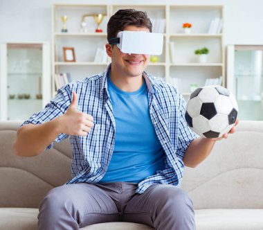 Sanal gerçeklik gözlüğü takan bir adam futbol maçı izliyor.