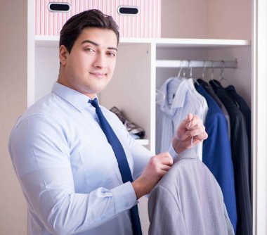 Genç işadamı iş için giyiniyor.