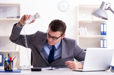 İşadamı ofis telefonundan konuşuyor.