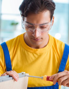 Mobilya marangozu atölyede çalışıyor.