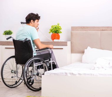 Genç yakışıklı engelli adam evde iyileşiyor.