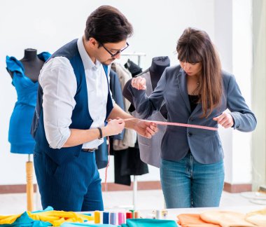 Profesyonel terzi resmi kıyafet için ölçü alıyor.