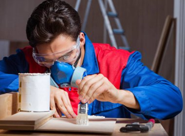 Genç adam ahşap parçaları DIY konseptinde yapıştırıyor.