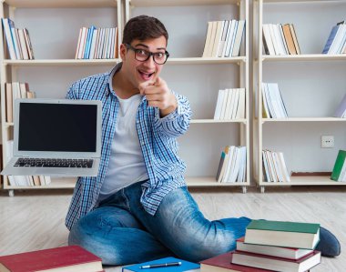 Genç öğrenci kitaplarla çalışıyor.