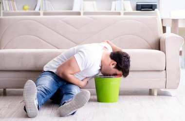 Midesi bulanan ve kusan bir adam.