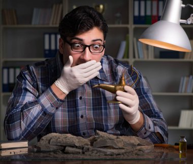 Arkeolog geç saatlere kadar ofiste çalışıyor.