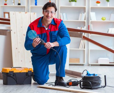 Genç marangoz ahşap kalaslarla çalışıyor.