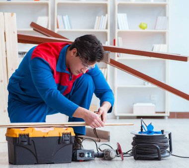 Genç marangoz ahşap kalaslarla çalışıyor.