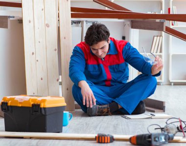 İnşaatta defter planlama yapan genç bir marangoz.