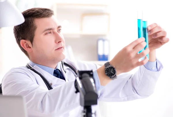 Männlicher Arzt schaut sich Laborergebnisse im Krankenhaus an — Stockfoto