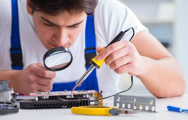 Computer repairman repairing desktop computer