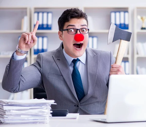 Clown affärsman på kontoret med en yxa — Stockfoto
