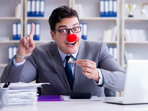 Clown affärsman bränna papper på kontoret — Stockfoto
