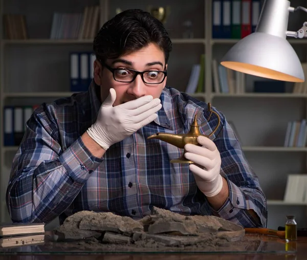 Arkeolog geç saatlere kadar ofiste çalışıyor.