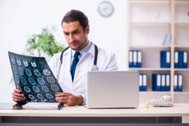 Klinikte çalışan yakışıklı genç bir doktor.