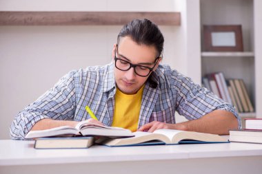 Genç erkek öğrenci sınava evde hazırlanıyor.