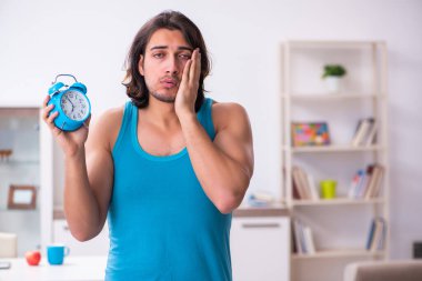 Genç adam evde uyanıyor.