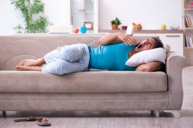 Genç adam evde uyanıyor.