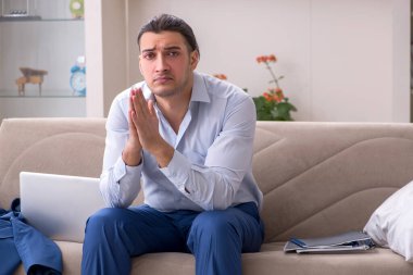 Evde çalışan genç bir erkek.