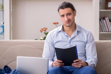 Evde çalışan genç bir erkek.