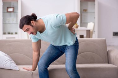 Evde acı çeken yaralı genç adam.