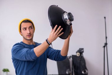 Stüdyoda çalışan genç bir fotoğrafçı.