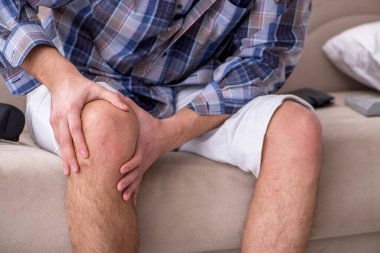 Genç bacağı yaralı adam evde acı çekiyor.