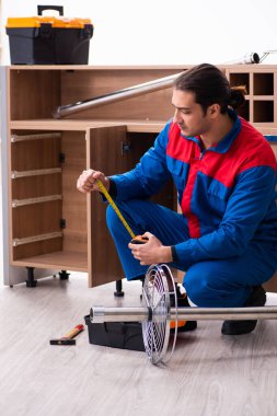 Genç yakışıklı erkek marangoz içeride çalışıyor.