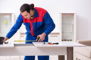 Genç erkek marangoz içeride çalışıyor.