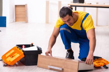 Genç erkek marangoz içeride çalışıyor.