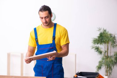 Genç erkek marangoz içeride çalışıyor.