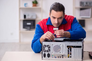 Bilgisayar tamir eden genç bir erkek tamirci.