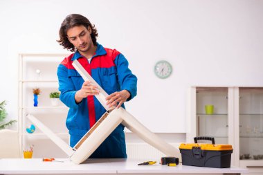 Genç erkek marangoz içeride çalışıyor.