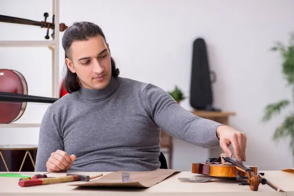 Young male repairman repairing violin — Stock Photo, Image