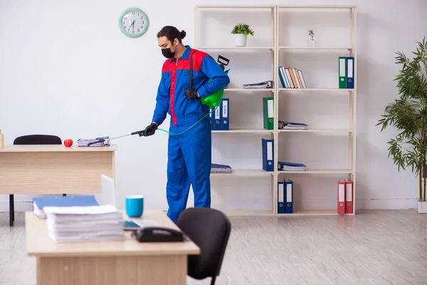 Contratista masculino joven desinfectando oficina — Foto de Stock