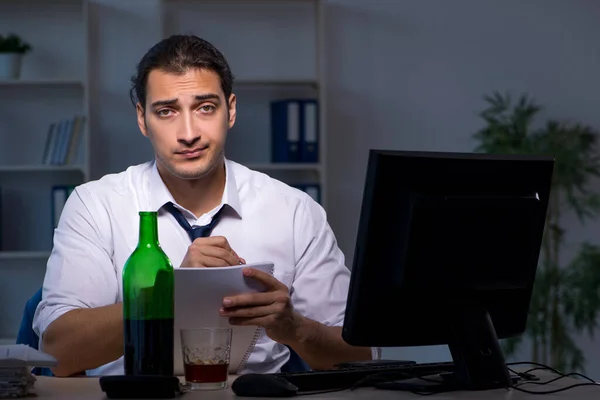 Алкоголикозависимый бизнесмен, работающий допоздна в офисе — стоковое фото