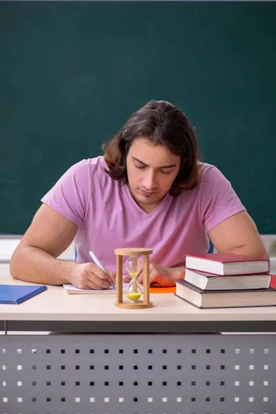 Giovane studente maschio in classe al concetto di gestione del tempo — Foto Stock