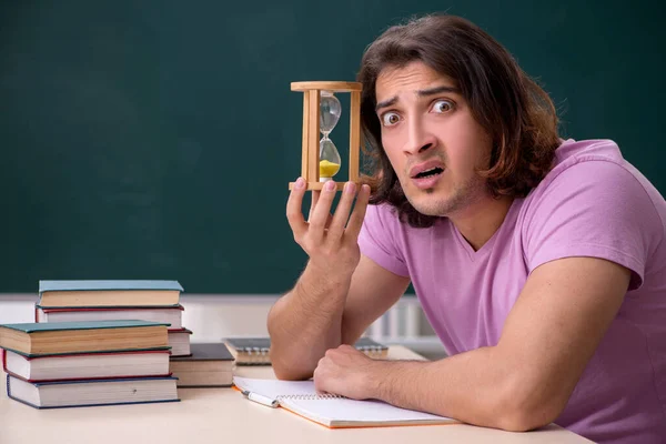 Young male student in the classroom at time management concept — Stock Photo, Image