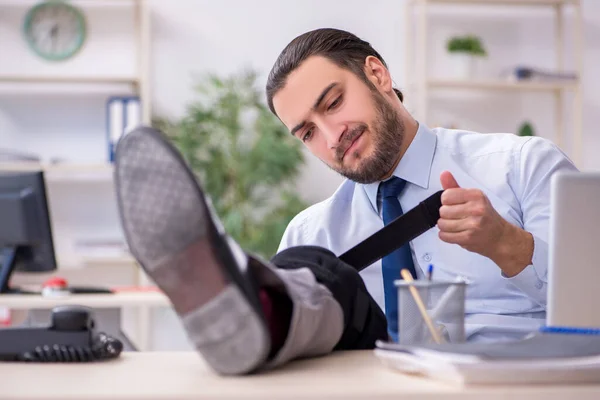 オフィスで働く若い脚の負傷者 — ストック写真