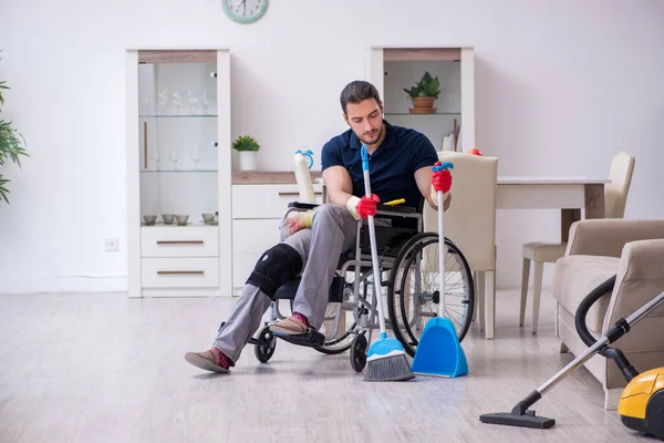 若い足が負傷した請負業者車椅子で家を掃除 — ストック写真