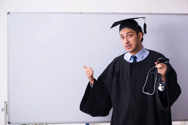 Joven graduado masculino delante de la junta —  Fotos de Stock