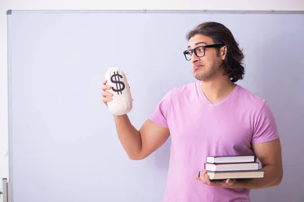 Young male student in front of board — Stock Photo, Image