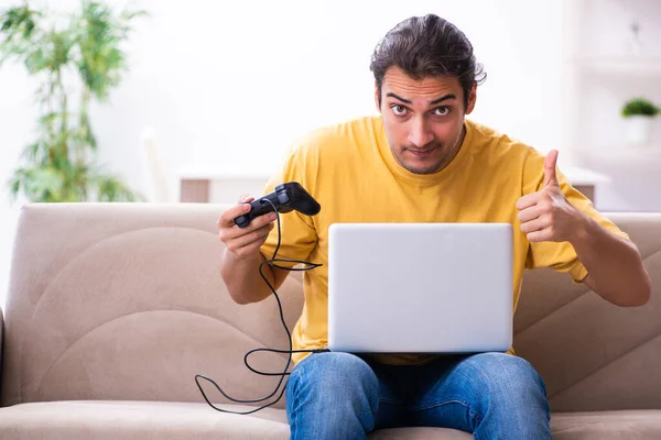 Jeune homme jouant à des jeux de joystick à la maison — Photo