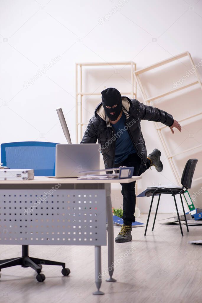 Young male burglar in the office