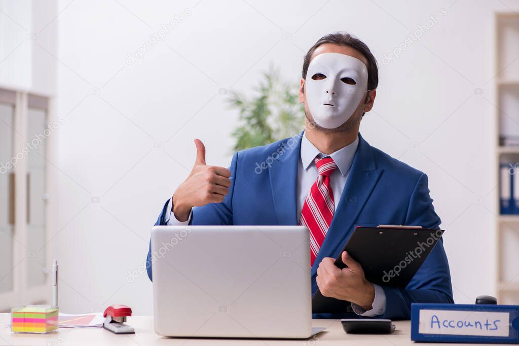Male employee with mask in hipocrisy concept