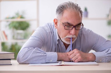 Sınıftaki yaşlı erkek öğretmen.