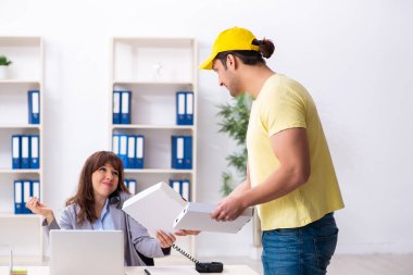 Genç erkek kurye ofise pizza getiriyor.